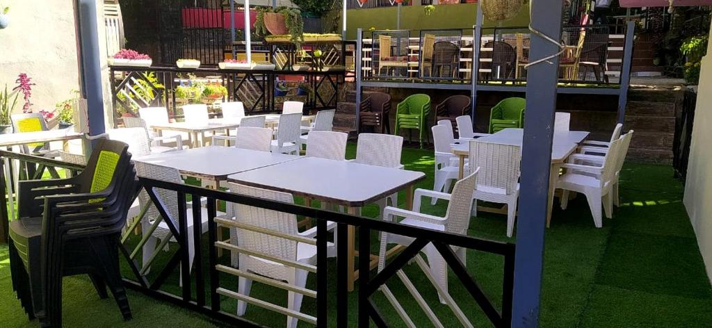 un ensemble de tables et de chaises blanches sur une terrasse dans l'établissement Baandal River Resort Maldevta, à Kokliyal Gaon