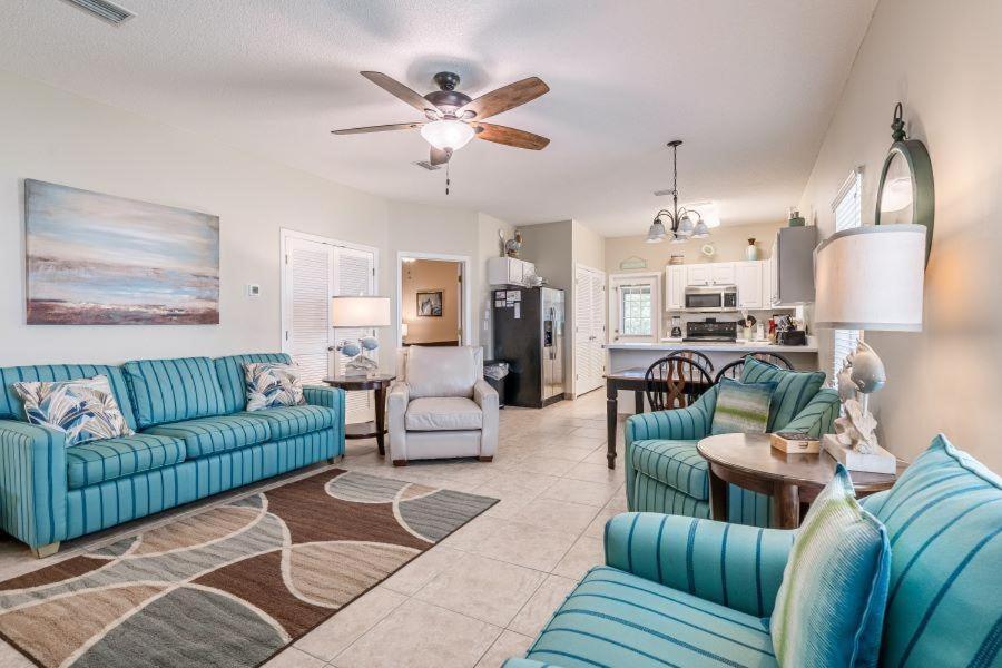 uma sala de estar com sofás azuis e uma cozinha em Orange Beach Villas - Casa Bella em Orange Beach