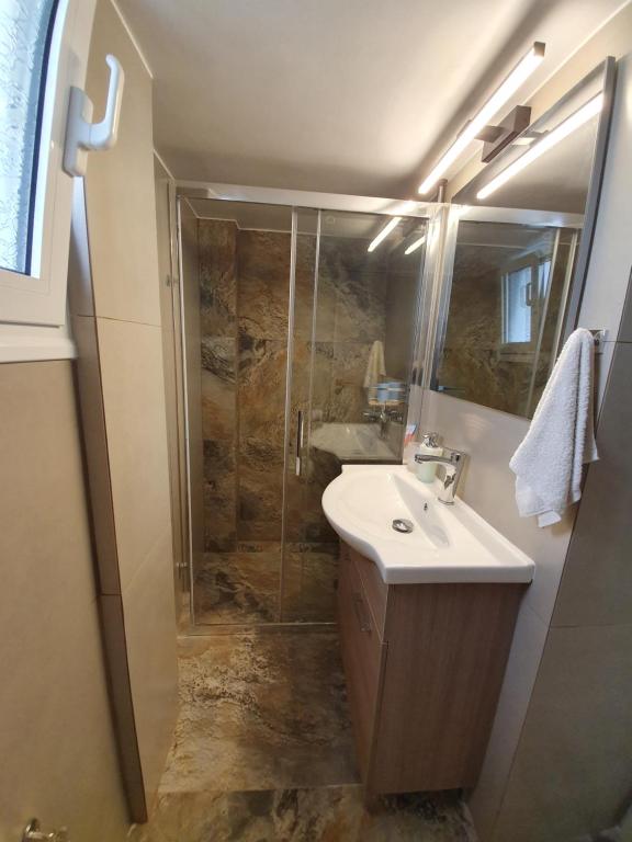 a bathroom with a shower and a sink and a shower at Stephie's apartment by the sea in Rafina