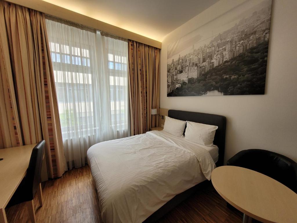 Cette chambre comprend un lit et une grande fenêtre. dans l'établissement Apart1hotel, à Luxembourg