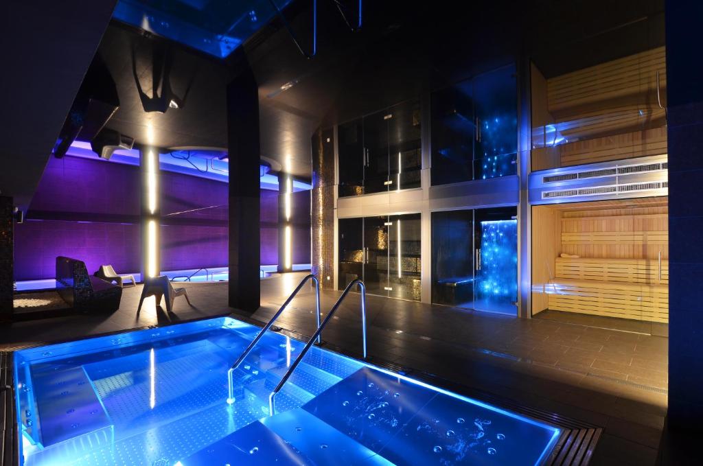 bañera en una habitación con iluminación púrpura en Hotel Spa Acevi Val d’Aran, en Vielha