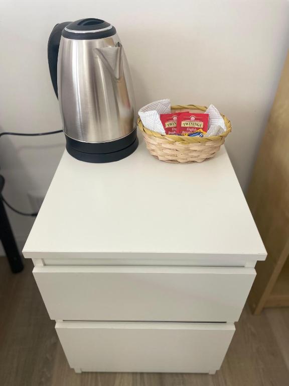 a coffee maker and a basket on a white drawer at Cerreto Suite Housing in Rome