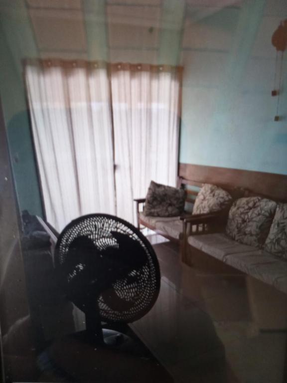 een woonkamer met een stoel en een bank bij Casa Cabo frio in Cabo Frio