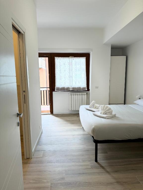 a white bedroom with a bed and a window at Cerreto Suite Housing in Rome