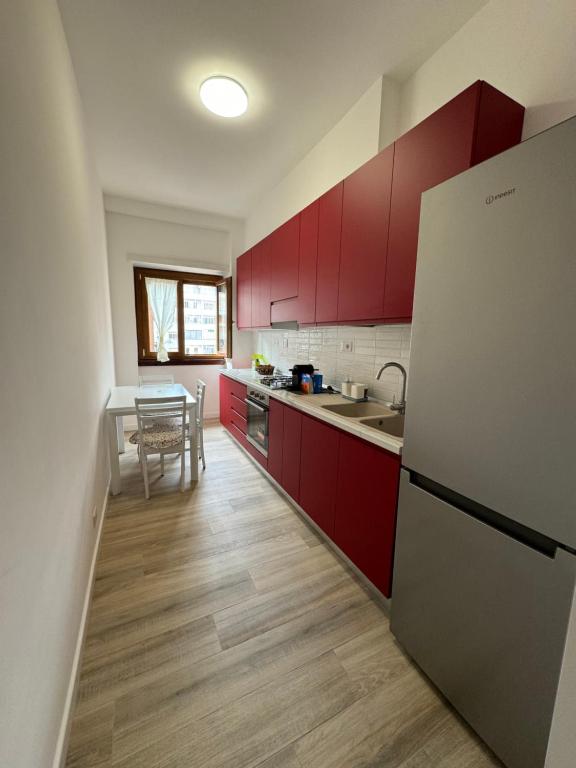 a kitchen with red cabinets and a refrigerator at Cerreto Suite Housing in Rome