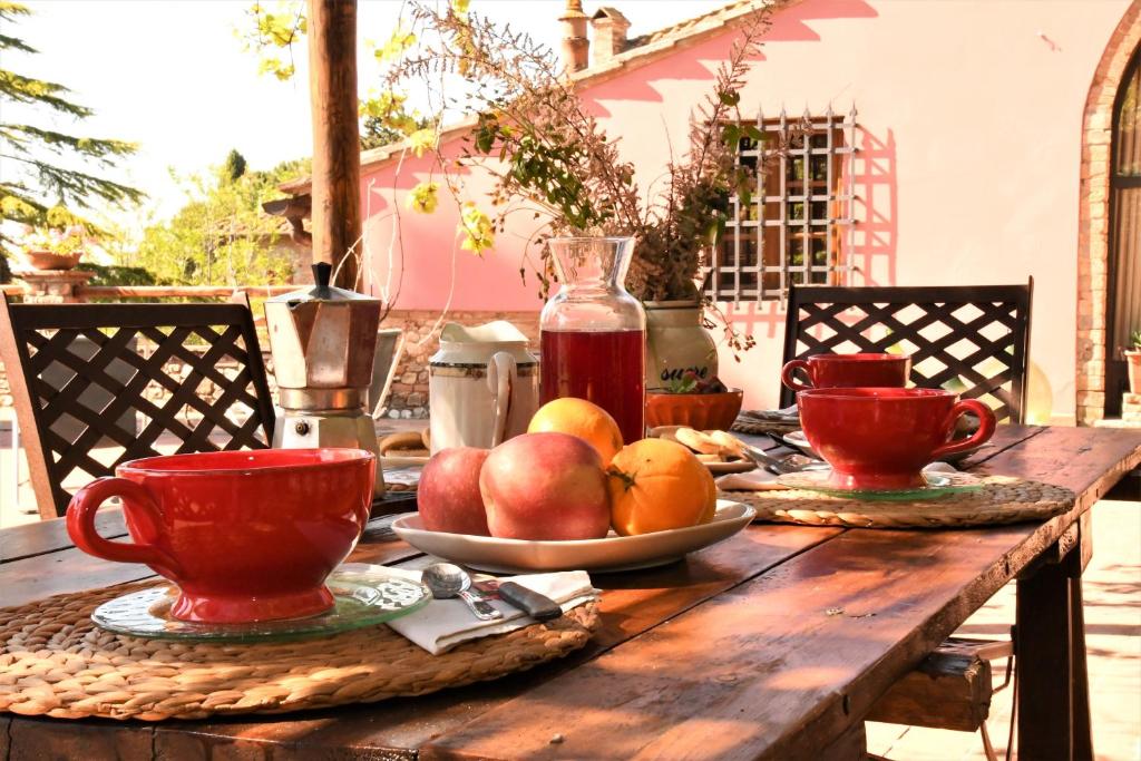 een houten tafel met fruitschalen erop bij Podere Casato in Montespertoli