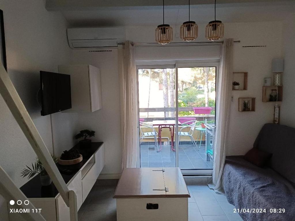 a living room with a couch and a sliding glass door at studio au cap d'agde dans les pinèdes in Cap d'Agde