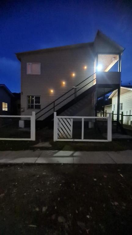 a house with a staircase in front of it at night at Radio Navarino in Puerto Williams