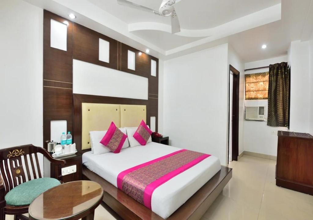 a bedroom with a bed and a desk and a table at Hotel University Stay @ A1Rooms in New Delhi