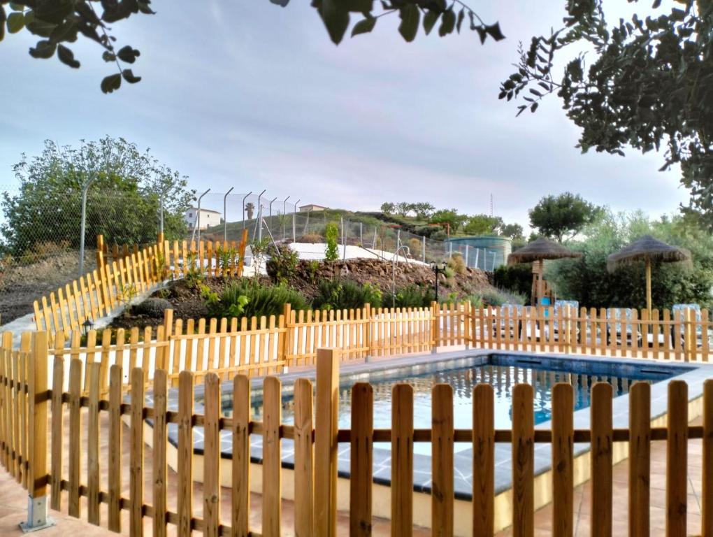 een houten hek rond een zwembad in een tuin bij Casa Rueapara in Torrox