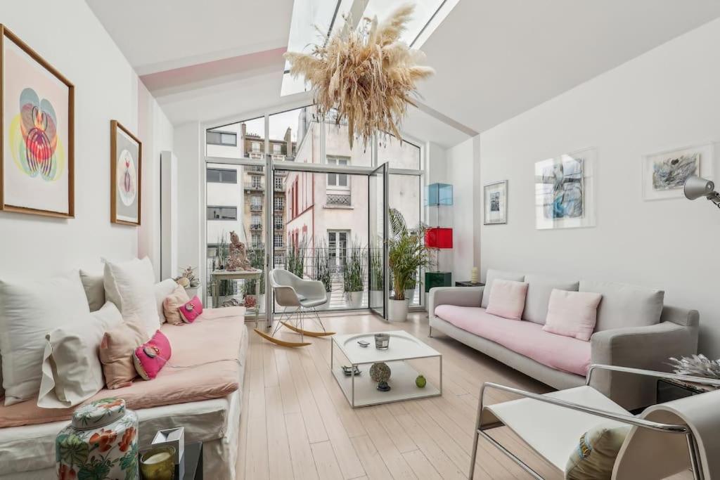 Elle comprend un salon doté d'un mobilier rose et d'une grande fenêtre. dans l'établissement Maison d'architecte Sacré Coeur, à Paris