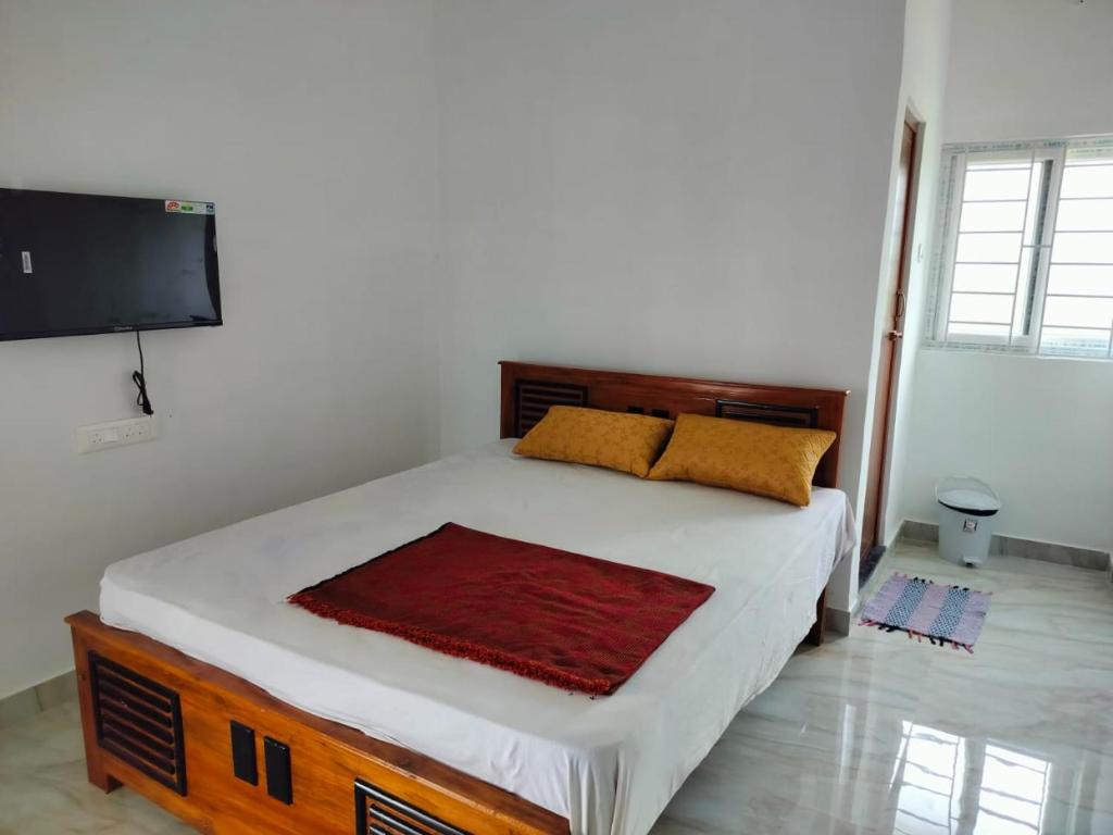 a bedroom with a bed and a flat screen tv at Aryas Residency in Coimbatore