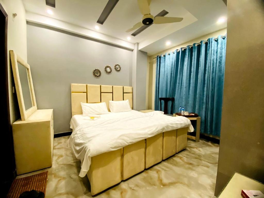 sypialnia z dużym łóżkiem i wentylatorem sufitowym w obiekcie Elite Living Hotels w mieście Rawalpindi