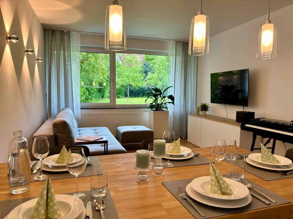 ein Wohnzimmer mit einem Tisch und einem Klavier in der Unterkunft Leo‘s MUNICH Apartment in München