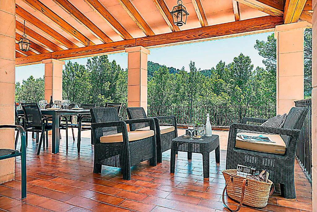 a patio with wicker chairs and tables on a porch at Holiday Villa Beauty Andratx in Capdellá