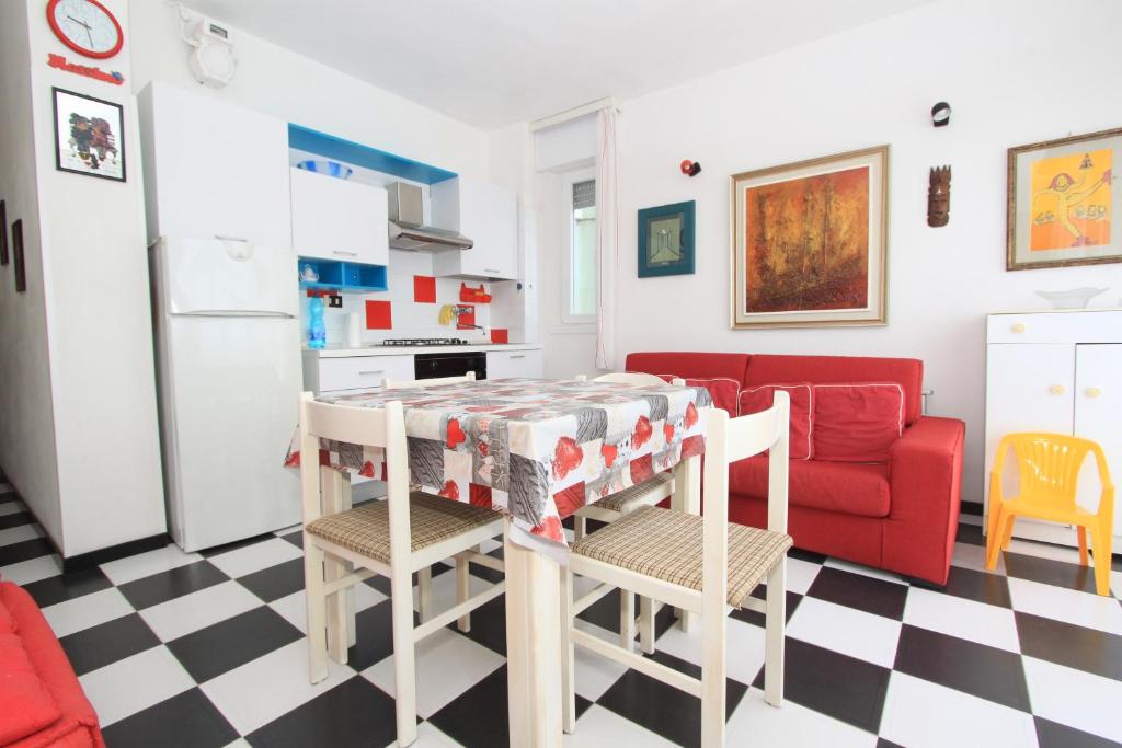 a kitchen and living room with a red couch at Eco del Mare Apartments in Lido di Pomposa