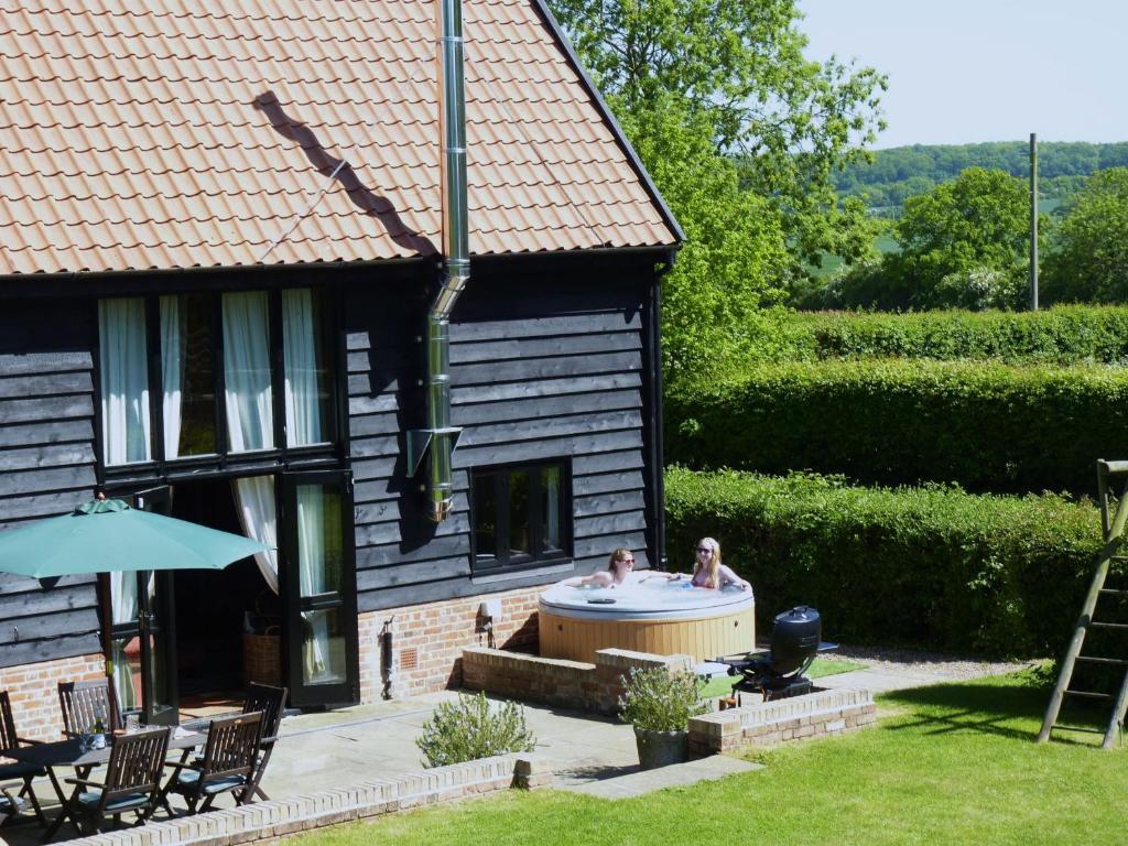 a house with a hot tub in the yard at Corner Farm Barn in Halesworth