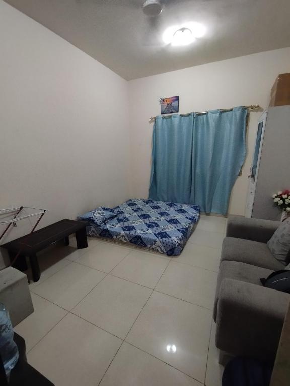 - un salon avec un lit et un canapé dans l'établissement Fully furnished room, à Charjah