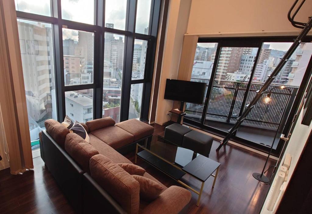 a living room with a couch and a large window at Neighbor's Penthouse 竹屋 in Hiroshima