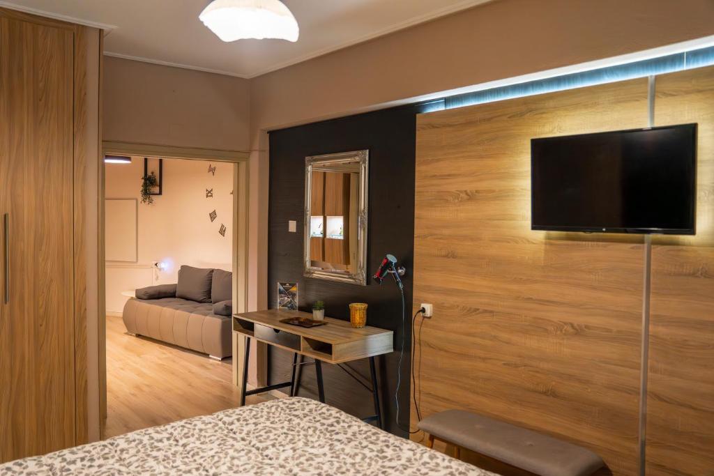 a room with a bed and a television on a wall at Perikleous 5 Diamerisma KONDOULIS HOUSE in Kalabaka