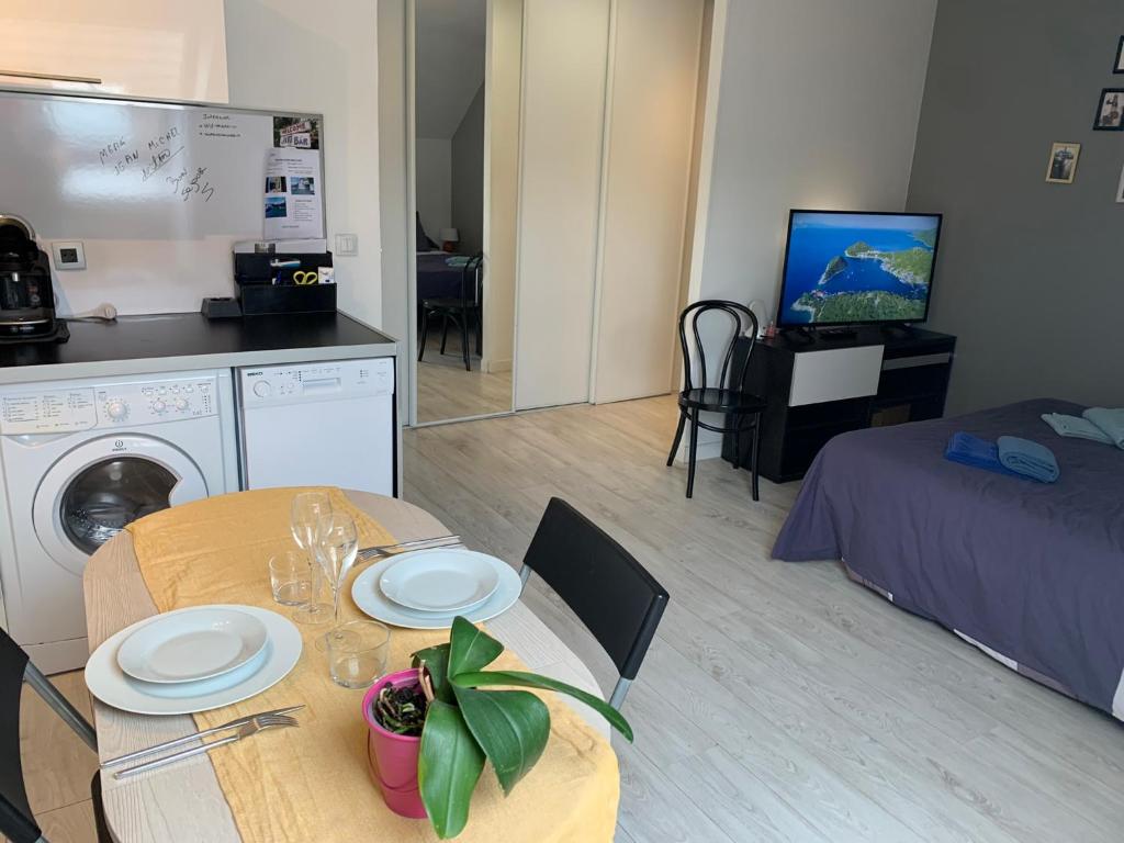 a room with a table and a kitchen and a bed at 96 Studio - Proche Disney & Paris - Tt équipée - calme - Parking privée in Pontcarré