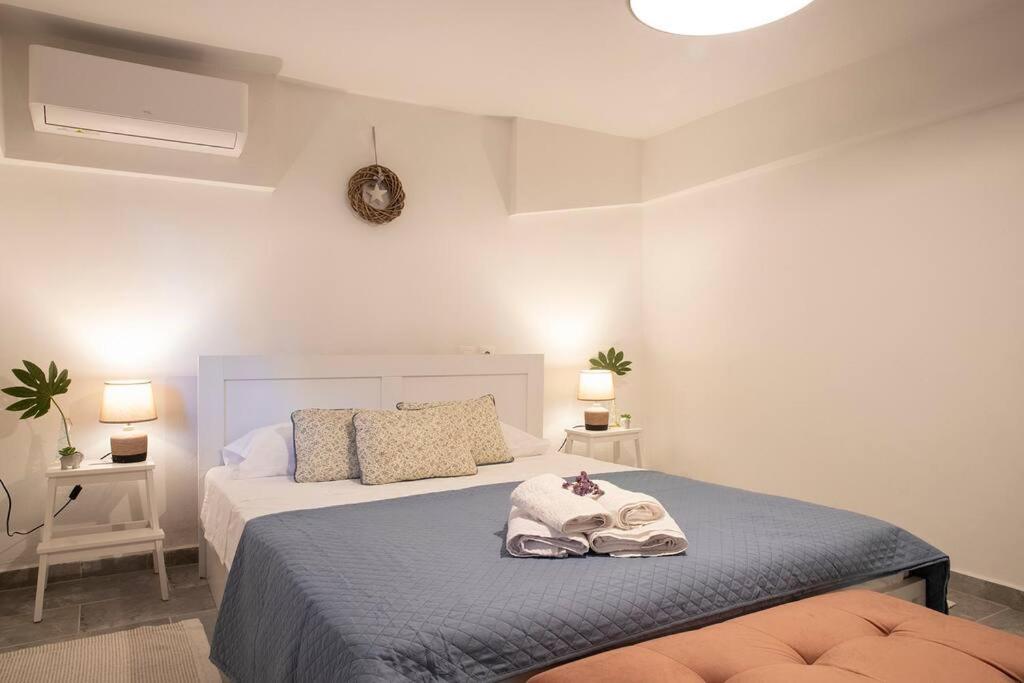 1 dormitorio con 1 cama grande y 2 lámparas en Alexandras guesthouse, en Neos Panteleimonas