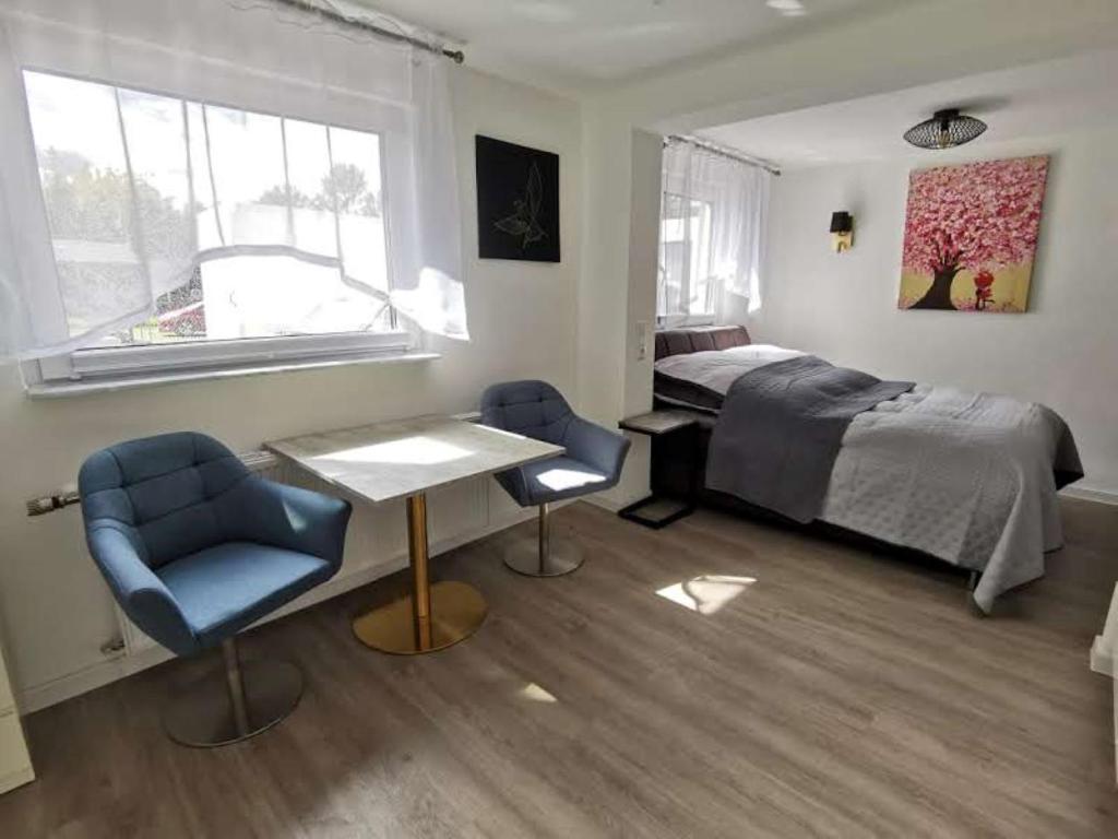 um quarto com uma cama, uma mesa e 2 cadeiras em Apartment bei der Palme mit Sauna Möglichkeit em Dusseldorf
