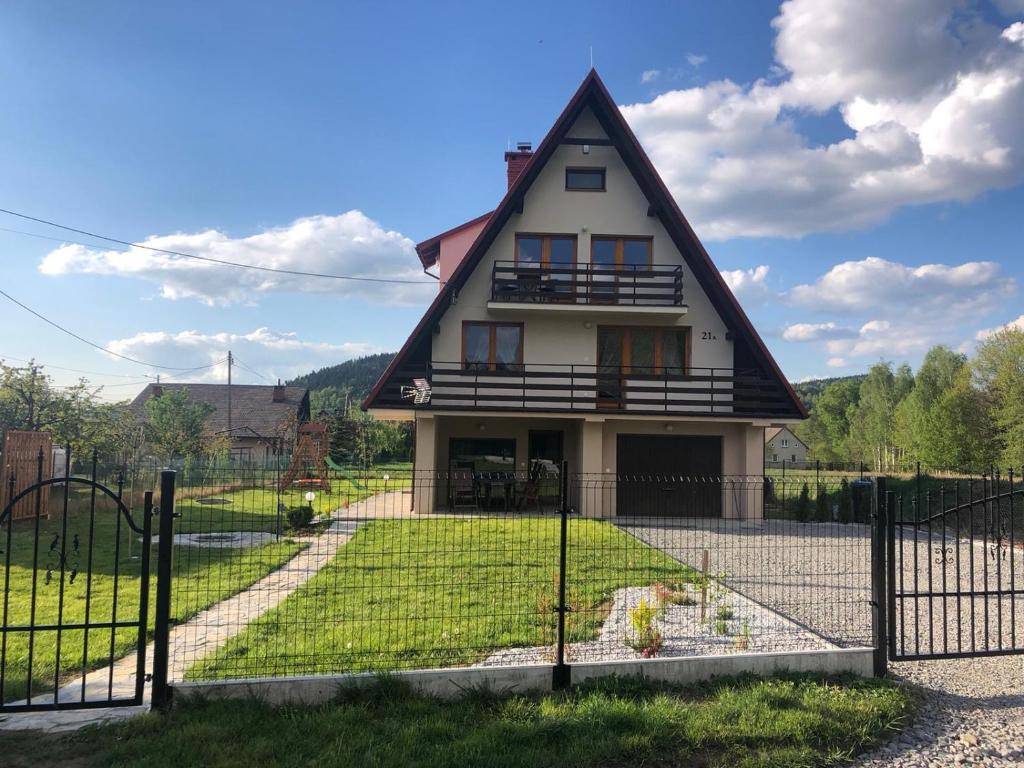 ein Haus mit einem Zaun davor in der Unterkunft Dom w Beskidach in Zagórnik