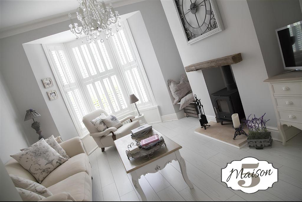 Una sala de estar con un sofá y una lámpara de araña. en Maison 5, en Harrogate