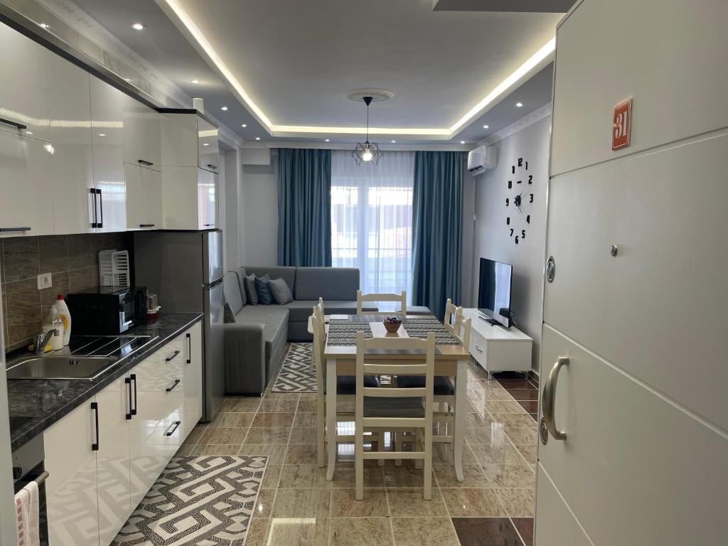 a kitchen and living room with a table and a couch at Fishta Quality Apartments Q5 31 in Velipojë