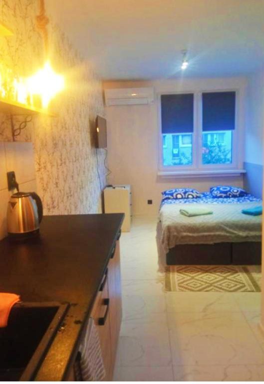une cuisine et une chambre avec un lit dans une pièce dans l'établissement NightHost Robotnicza 32 m248 Wrocław, à Wrocław