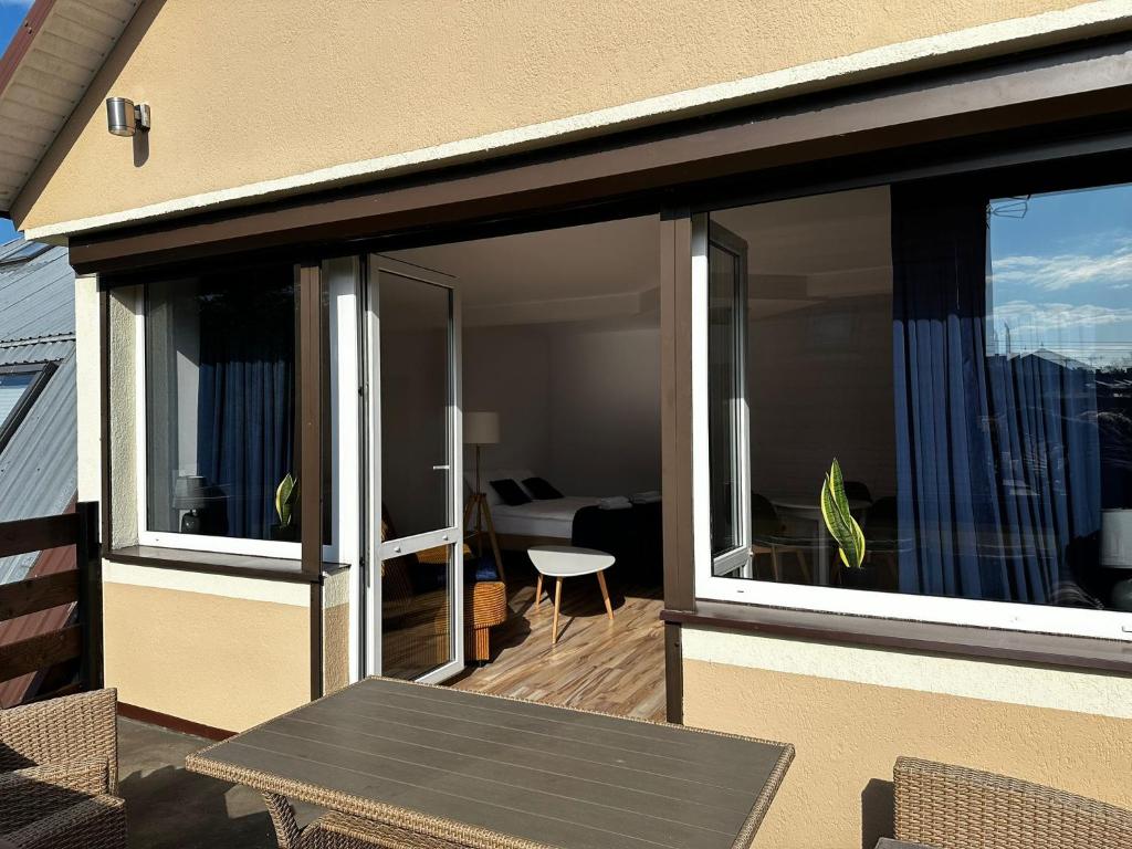 韋巴的住宿－Pokoje Gościnne Nad Morzem，阳台设有滑动玻璃门和桌子。