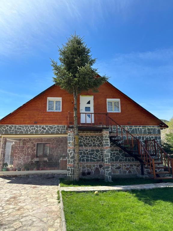a house with a tree on the side of it at Shtepi Druri Arber in Voskopojë
