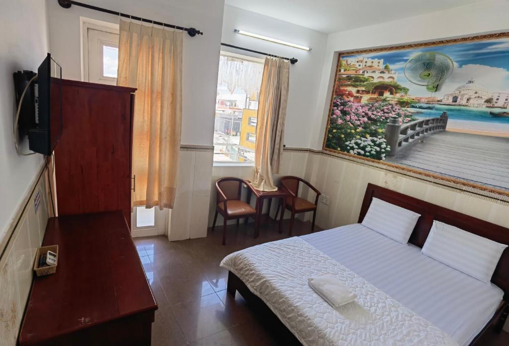 ein Schlafzimmer mit einem Bett und einem Wandgemälde in der Unterkunft KHÁCH SẠN Như Ý in Ho-Chi-Minh-Stadt