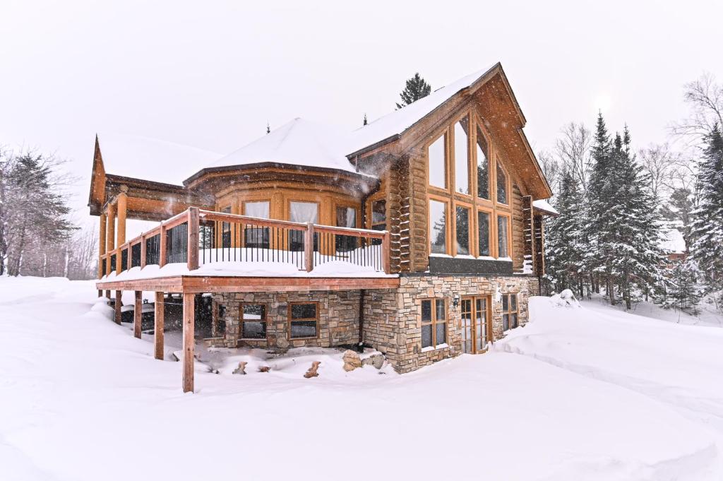 ein Blockhaus im Schnee mit Schnee in der Unterkunft Fiddler lake Resort Chalet 86 Deer in Mille-Isles