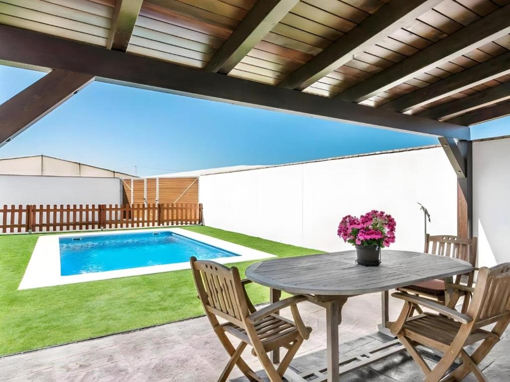 a patio with a table and chairs and a pool at Bungalow para familias y parejas in Cádiz