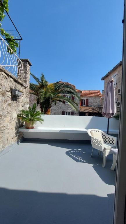 a patio with a table and a chair on a building at Villa Urbana, Old Town Budva in Budva