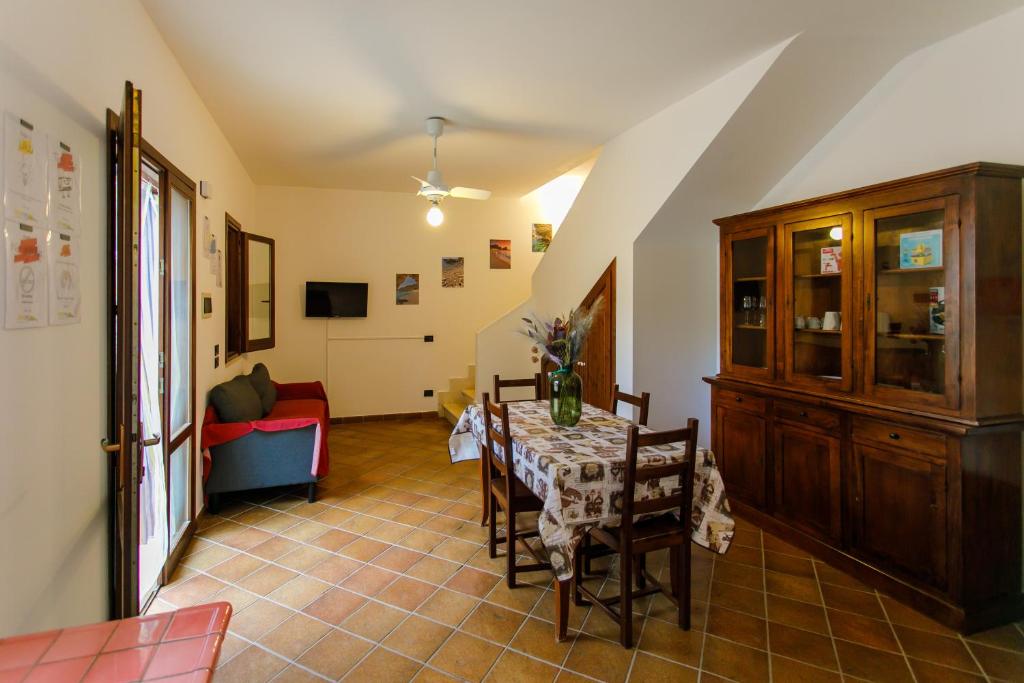 a dining room with a table and a red couch at SanVitoTour- Residence Il Baglio in San Vito lo Capo
