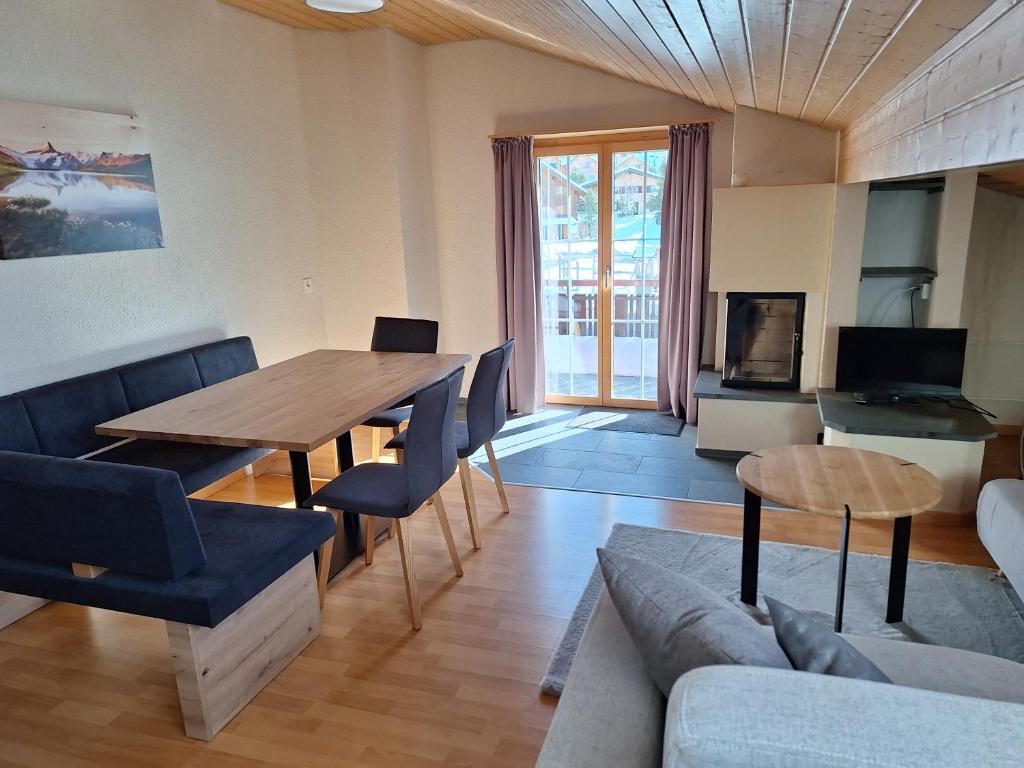 sala de estar con mesa de madera y sofá en Ferienwohnungen Walserhof Malbun en Malbun