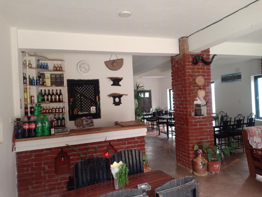 a living room with a brick fireplace and a bar at Maya Hotel in Bandīpur