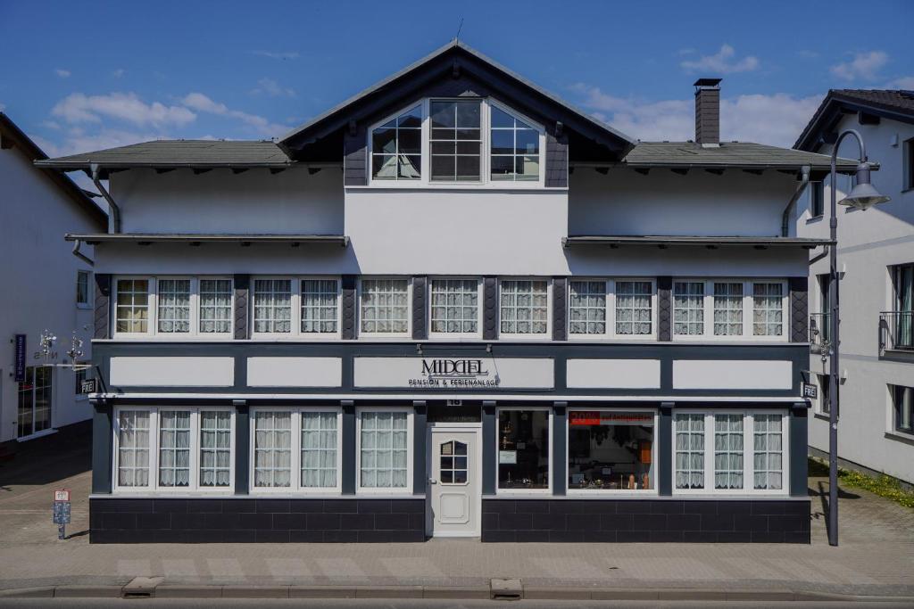 a black and white building with a store at Pension Middel in Binz