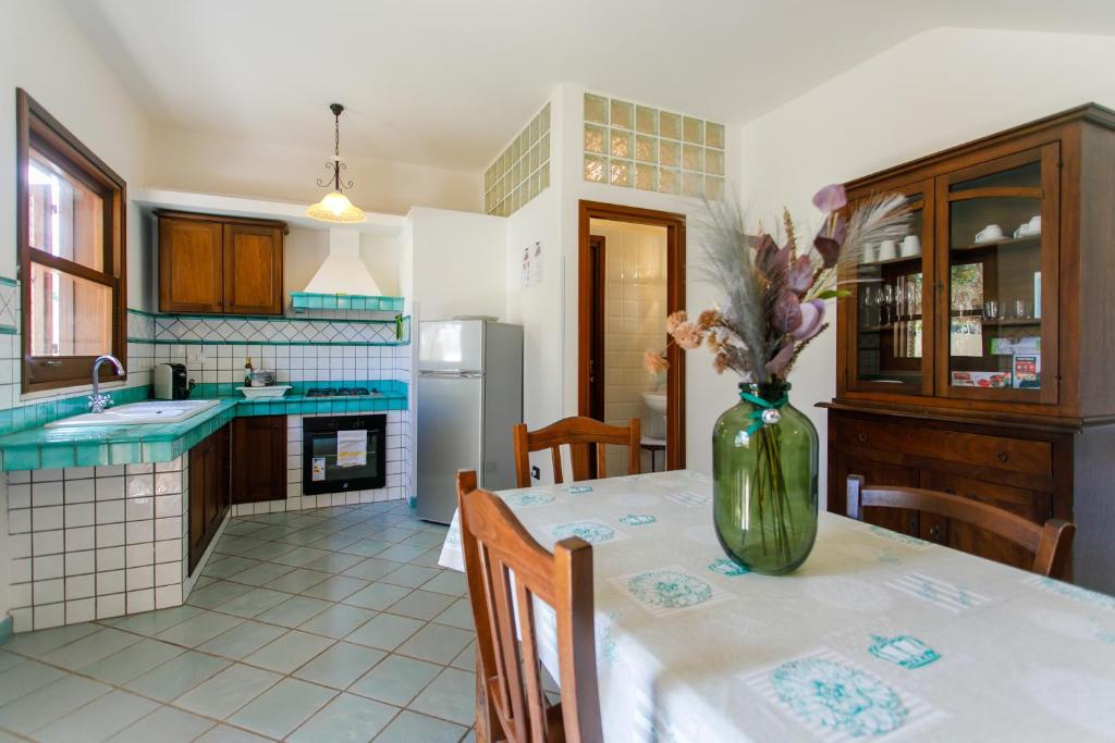 a kitchen with a table with a vase of flowers on it at SanVitoTour- Residence Il Baglio in San Vito lo Capo
