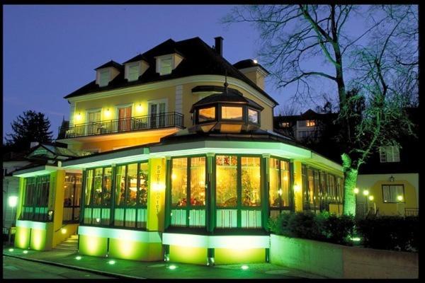 a large building with a lot of windows at night at Parkhotel Neubauer in Sauerbrunn