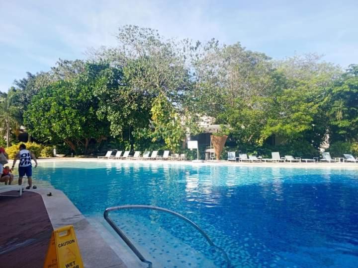 a person standing next to a swimming pool at Tambuli Resort Tower D in Lapu Lapu City