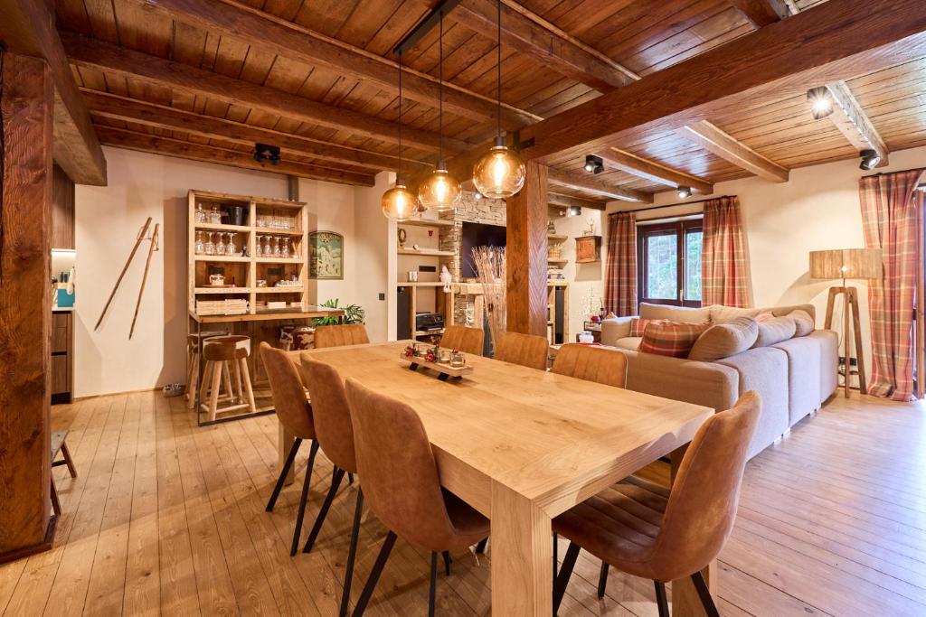 a dining room and living room with a table and chairs at Pleta del Tarter 31A Lodge & SPA in Canillo