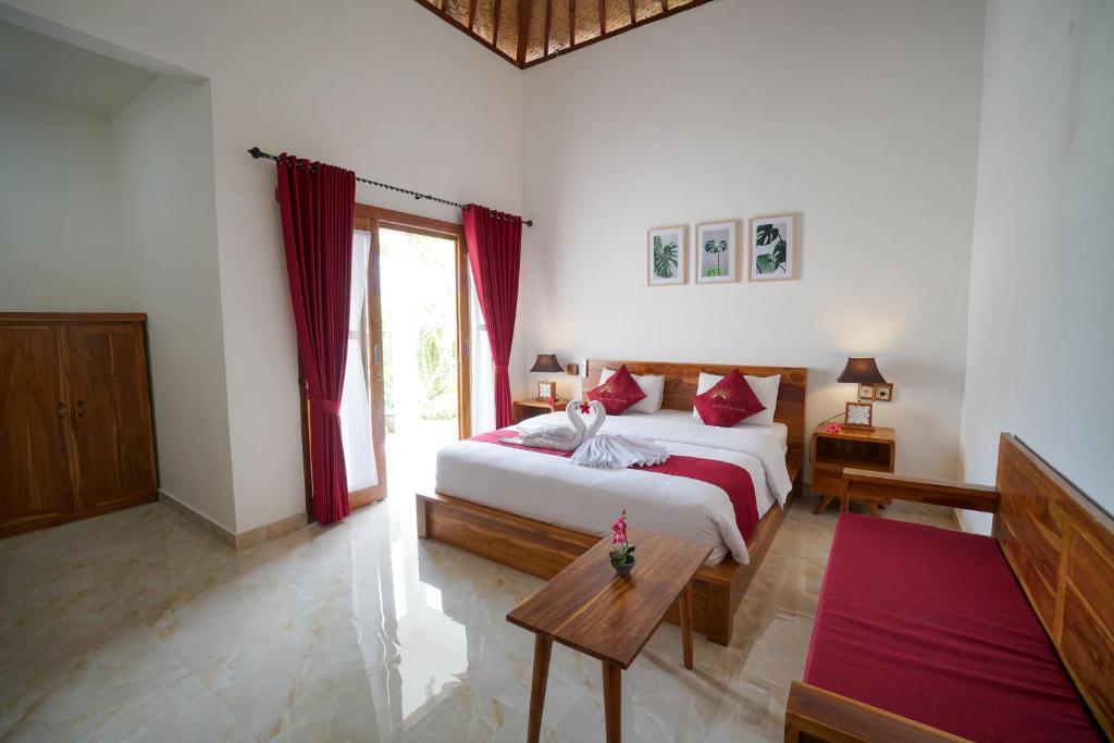 a bedroom with a large bed with red curtains at Innora Jungle Resort And Spa in Nusa Penida