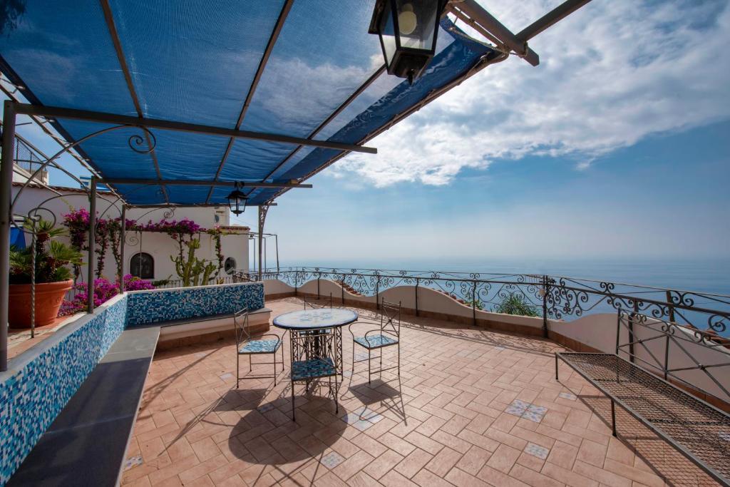 a balcony with a table and chairs and the ocean at Charming Villa, with terrace overlooking the sea, Amalfi coast, 170 steps from the road in Conca dei Marini