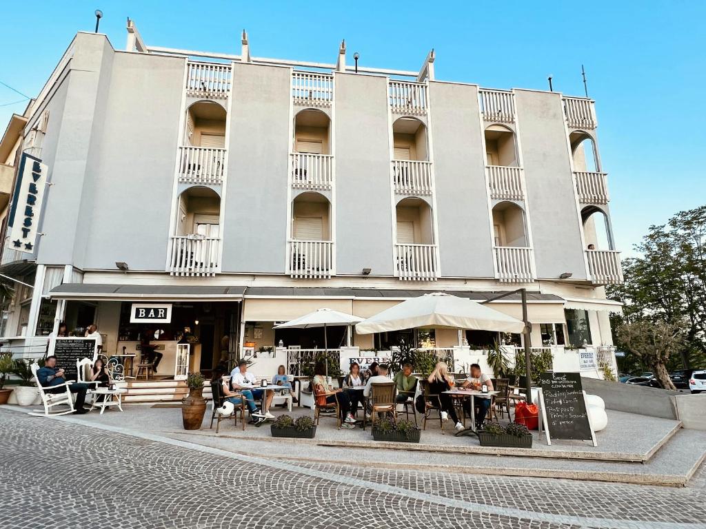 people sitting at tables in front of a building at B&B Everest Bar Ristorantino in Gabicce Mare