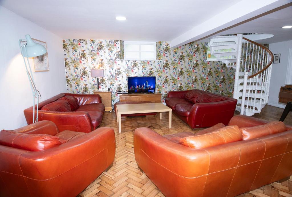 a living room with leather couches and a tv at Spacious house Liverpool city centre L1, sleeps 16 in Liverpool