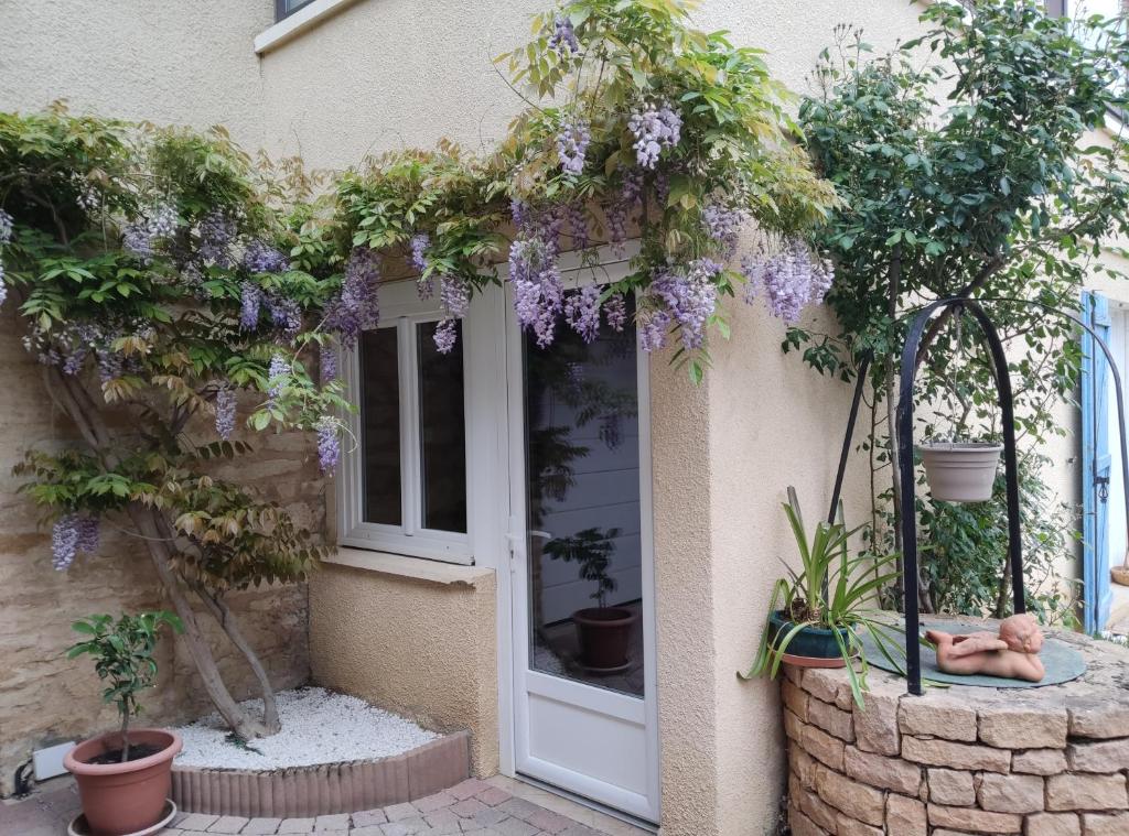 una entrada a una casa con flores púrpuras en Chambres d'hôtes - Les Varennes, en Saint-Georges-de-Reneins